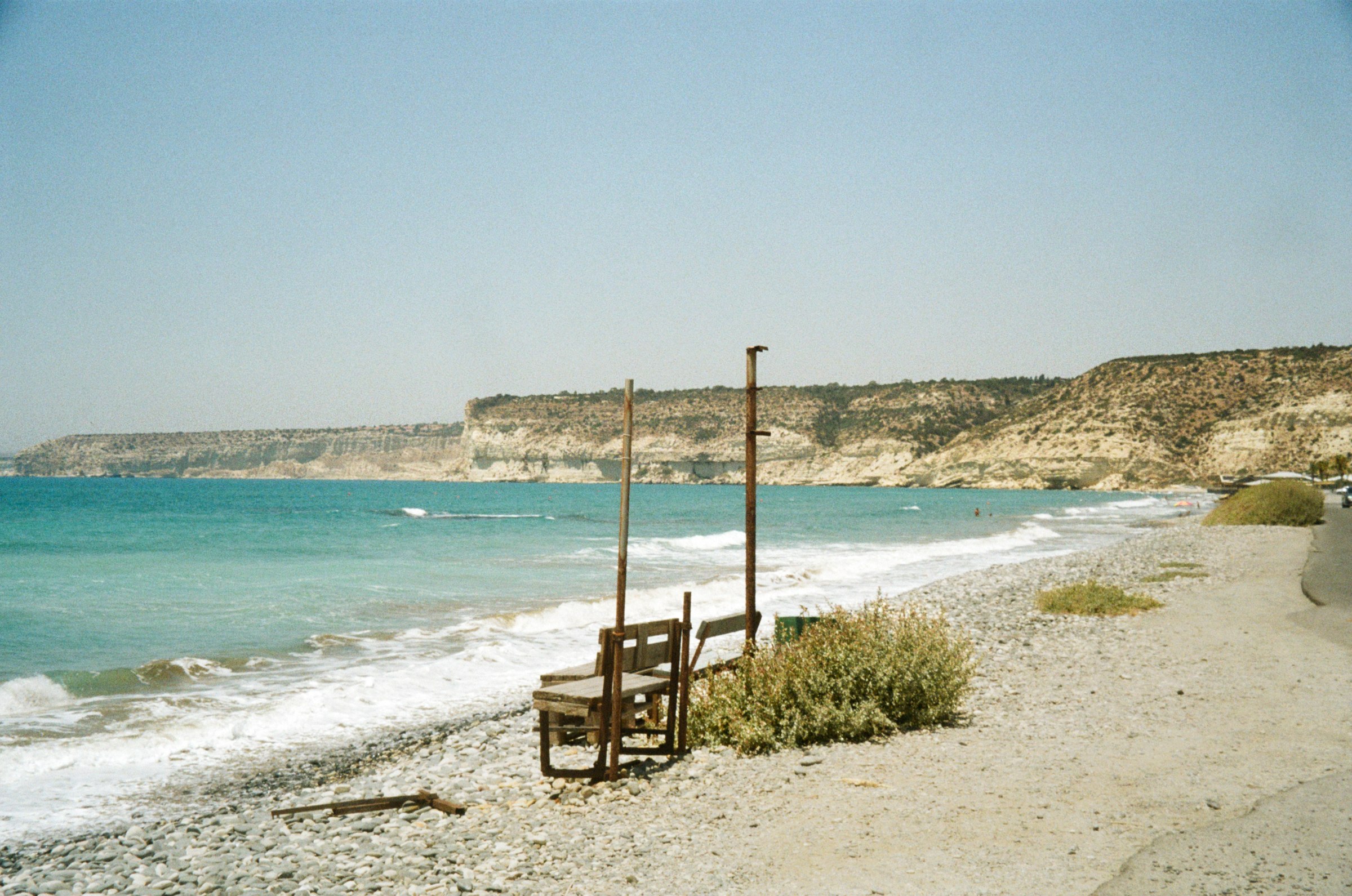 Weathered beach chairs on a quiet pebble beach