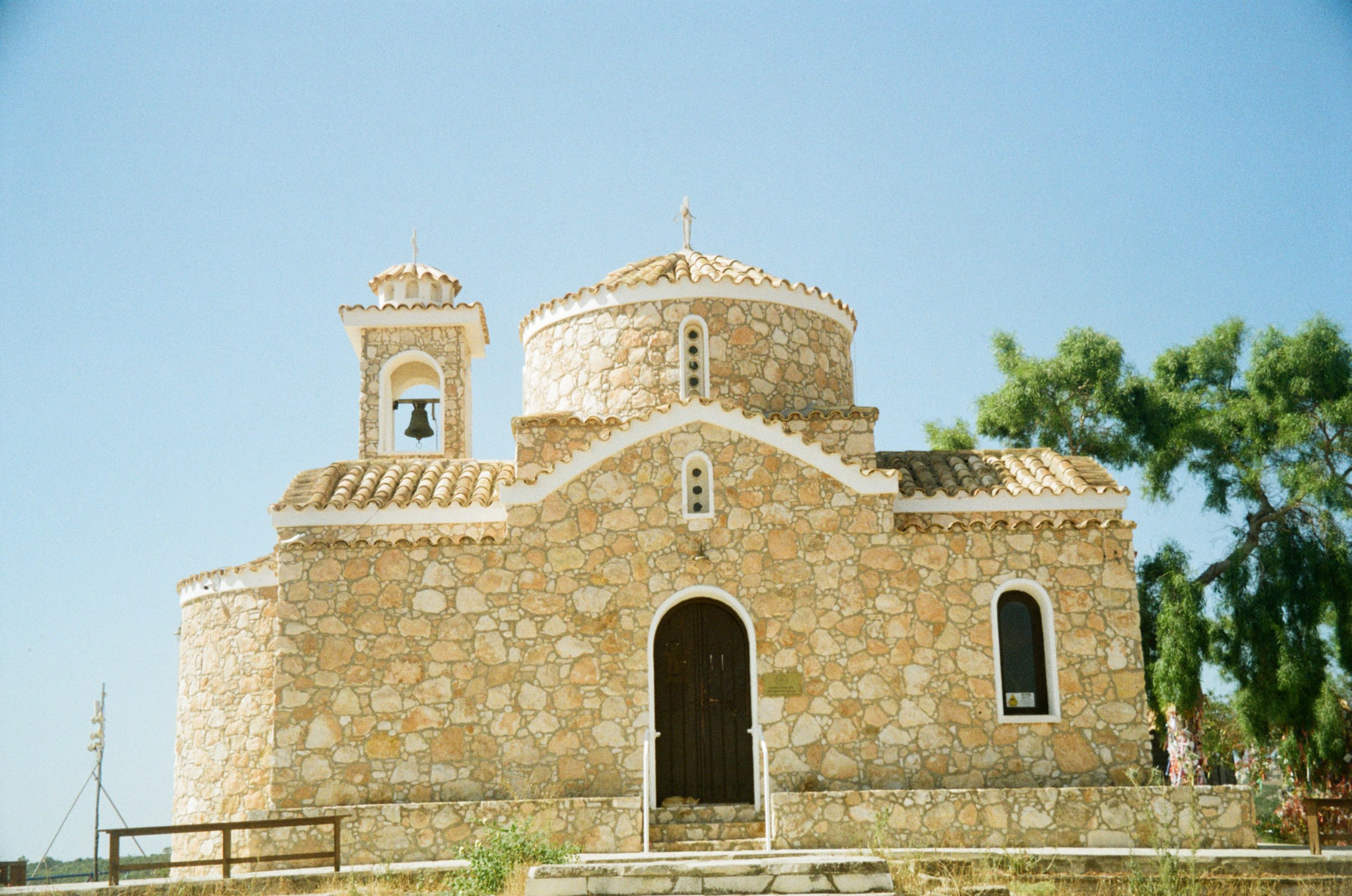 A rustic stone church with a bell tower