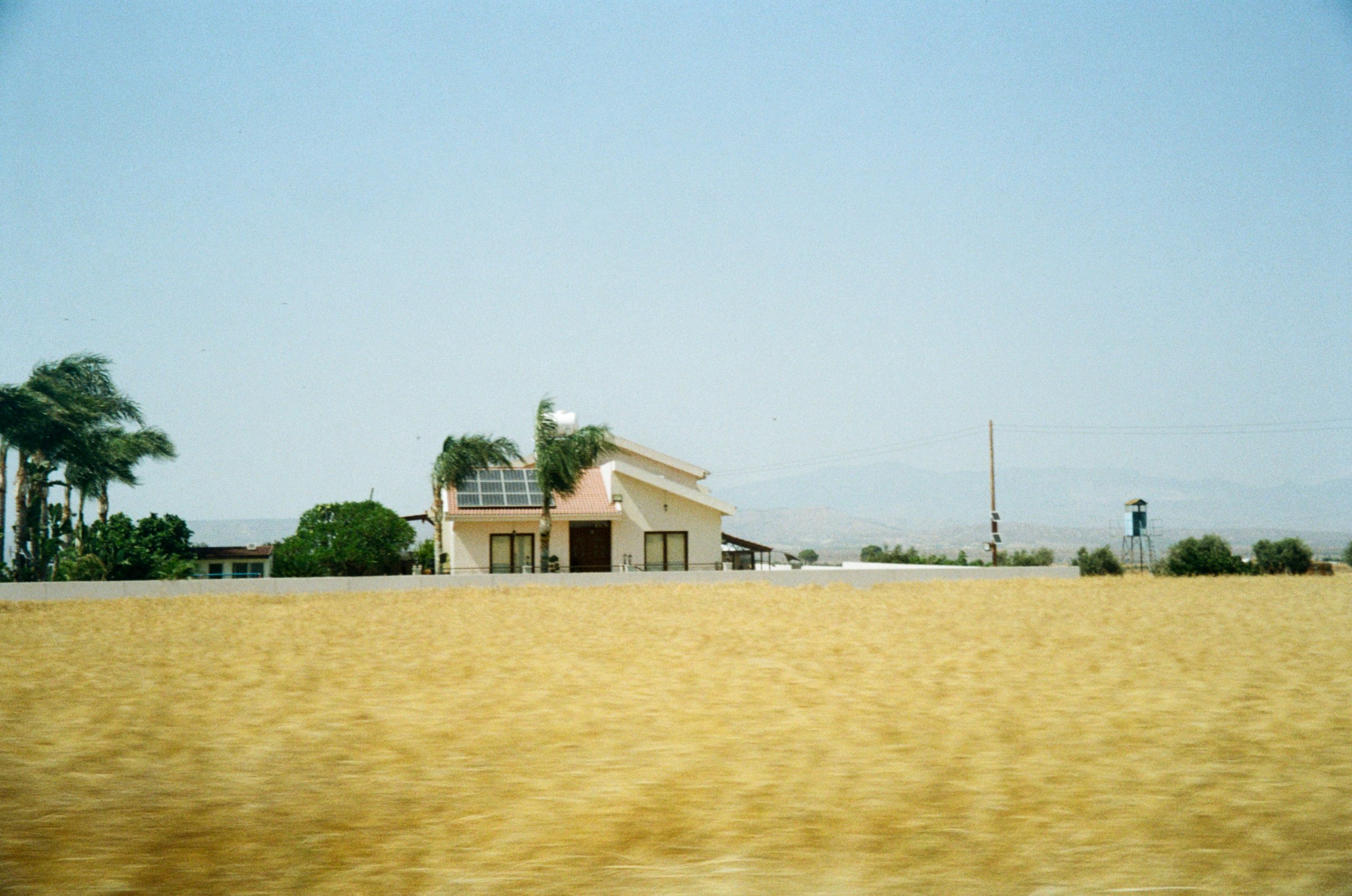 A villa beyond a golden wheat field