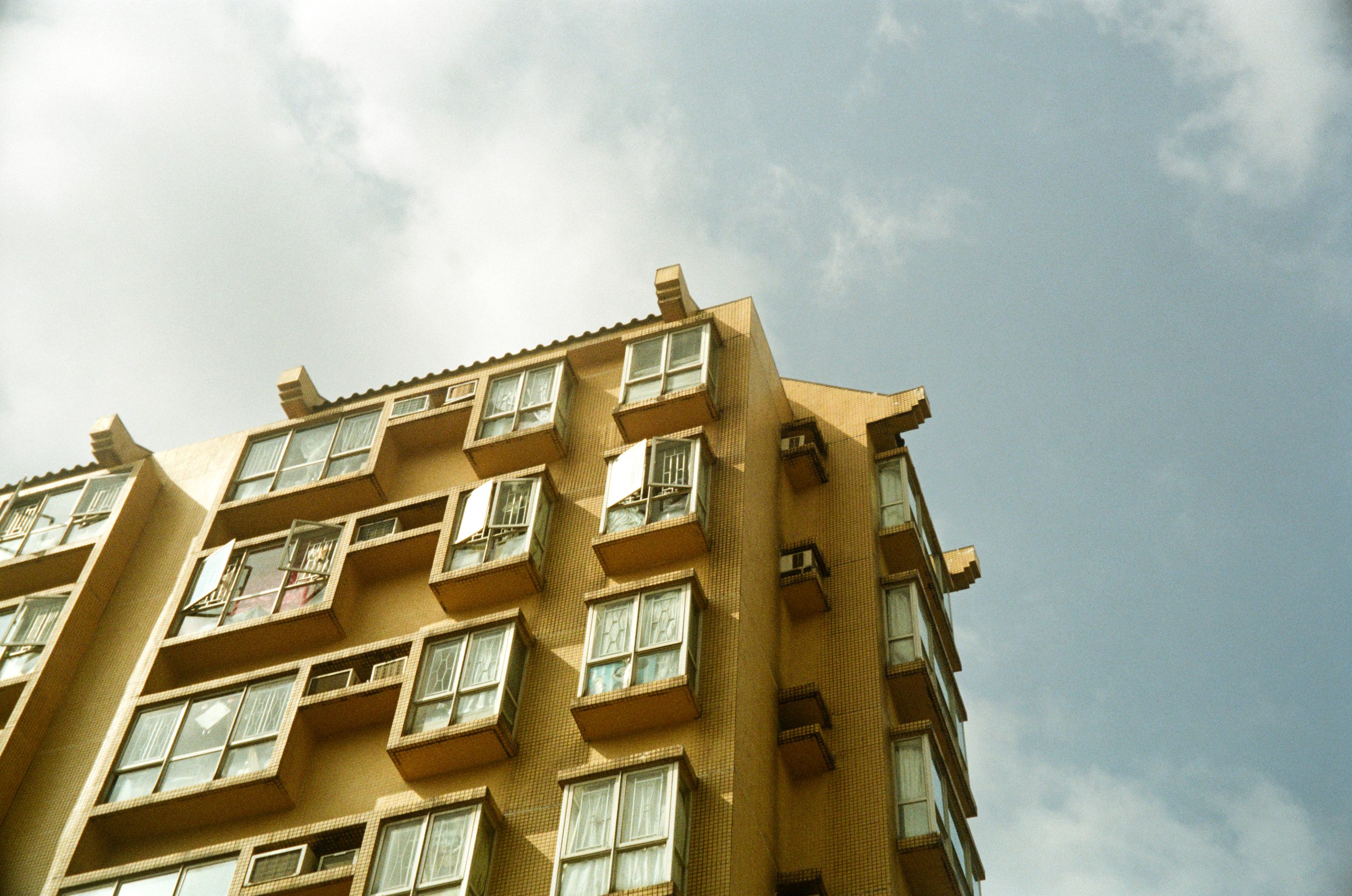 Looking up at an apartment tower against the sky